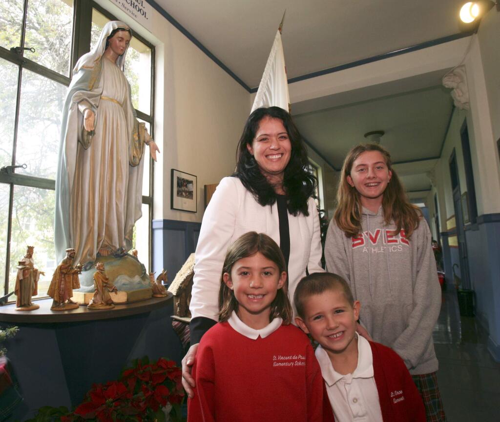St. Vincent de Paul Elementary School principal Stephanie Qunilan with students Lauren and Gavin, both 1st grade, and Olivia, 7th grade, on Tuesday December 9, 2014. (SCOTT MANCHESTER/ARGUS-COURIER STAFF)