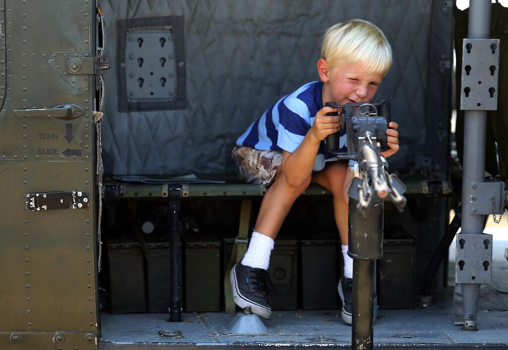 Callen Lee, 8, pretends to be the side gunner on a Huey helicopter at the Tribute to Vietnam Veterans at the Pacific Coast Air Museum. (JOHN BURGESS / The Press Democrat)