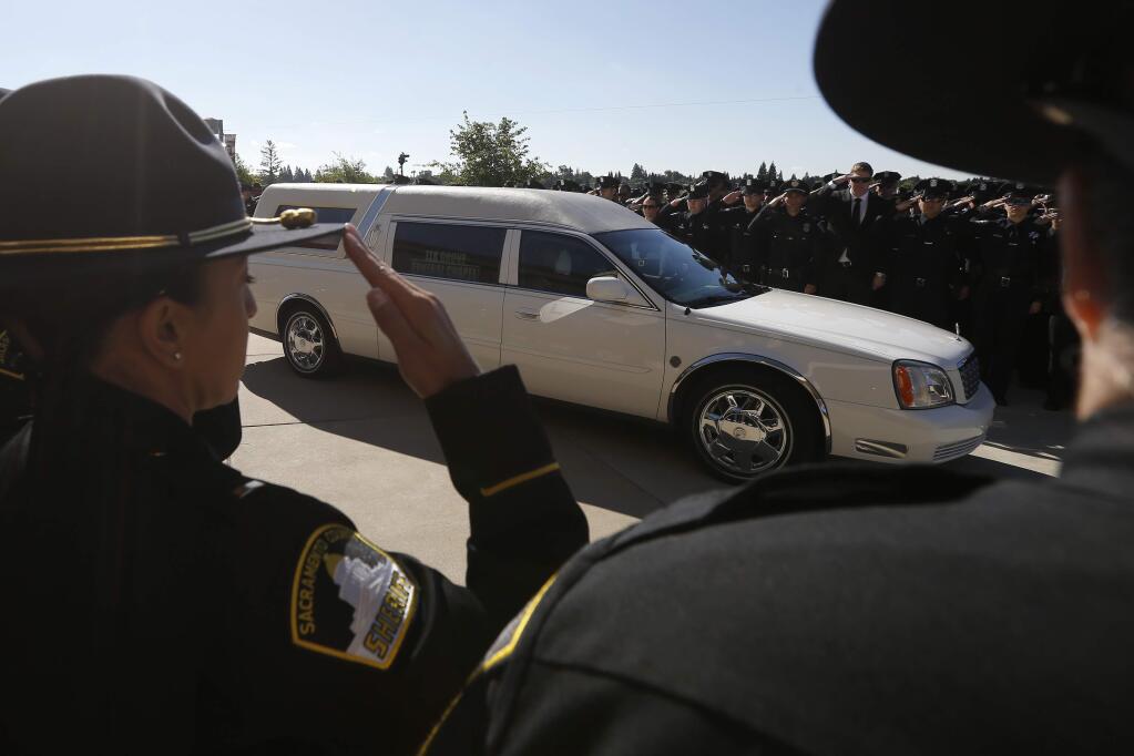 Law enforcement officers salute the hearse carrying the casket of Sacramento Police Officer Tara O'Sullivan to the Bayside Adventure Church for memorial services in Roseville, Calif., Thursday, June 27, 2019. O'Sullivan was shot and killed last week responding to a domestic violence call. (AP Photo/Rich Pedroncelli)