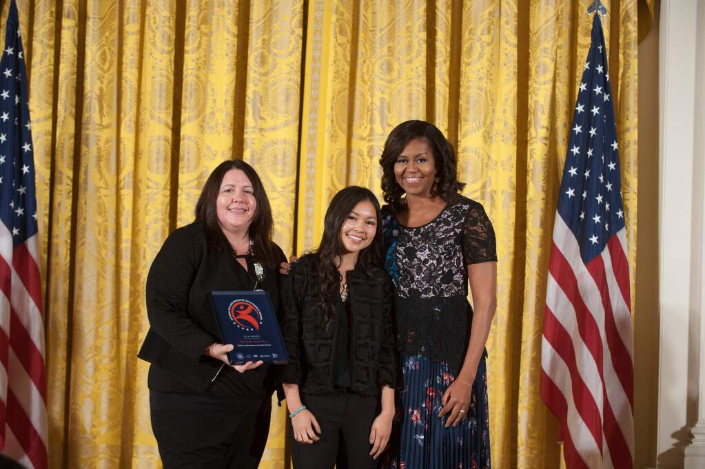 Jayden Lim, 15 (center), and her mother, Nicole Lim, accept the 2016 National Arts and Humanities Youth Program Award from First Lady Michelle Obama in a ceremony at the White House, Nov. 15, 2016. (Photo: Steven E. Purcell / Flickr)