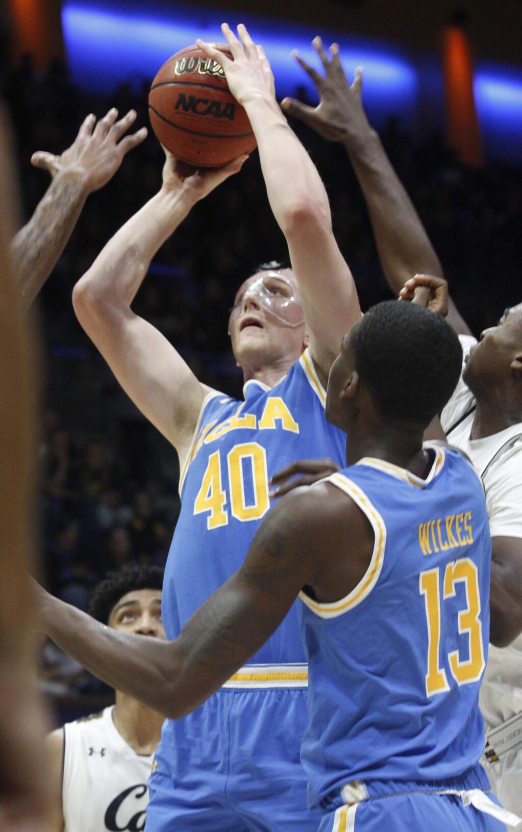 UCLA's Thomas Welsh (40) shoots in front of teammate Kris Wilkes (13) as California's Juhwan Harris-Dyson defends during the first half of an NCAA college basketball game Saturday, Jan. 6, 2018, in Berkeley, Calif. (AP Photo/George Nikitin)