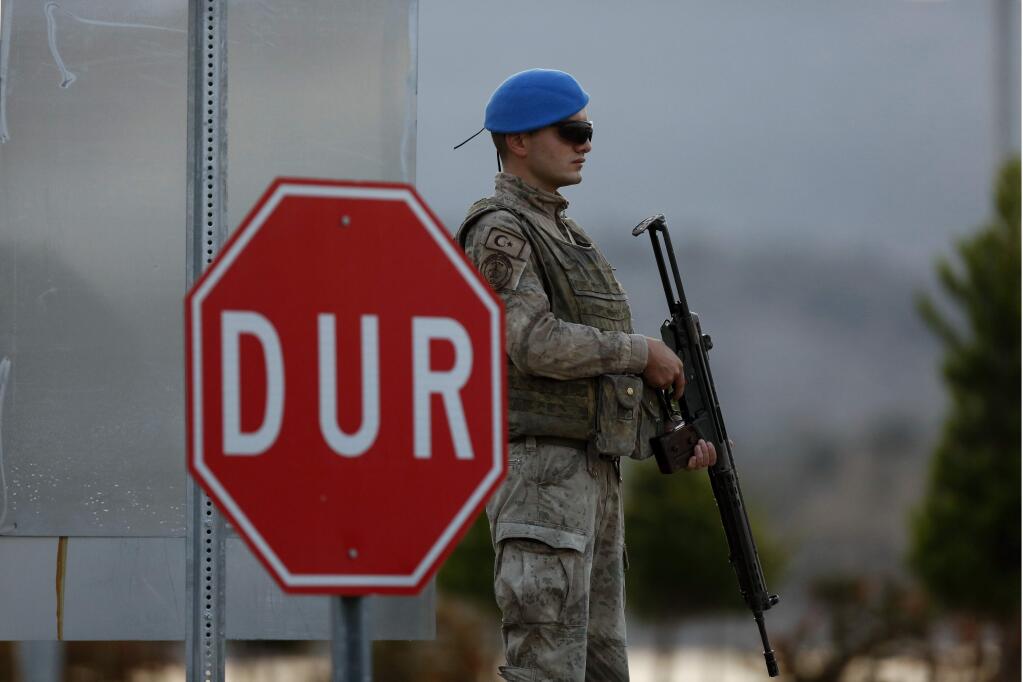 A Turkish soldier stands next to a sign that reads 'Stop' in Turkish outside a courthouse, shortly before US pastor Andrew Brunson was released following his trial in Izmir, Turkey, Friday, Oct. 12, 2018, A Turkish court on Friday convicted an American pastor of terror charges but released him from house arrest and allowed him to leave Turkey, in a move that is likely to ease tensions between Turkey and the United States. (AP Photo/Emrah Gurel)