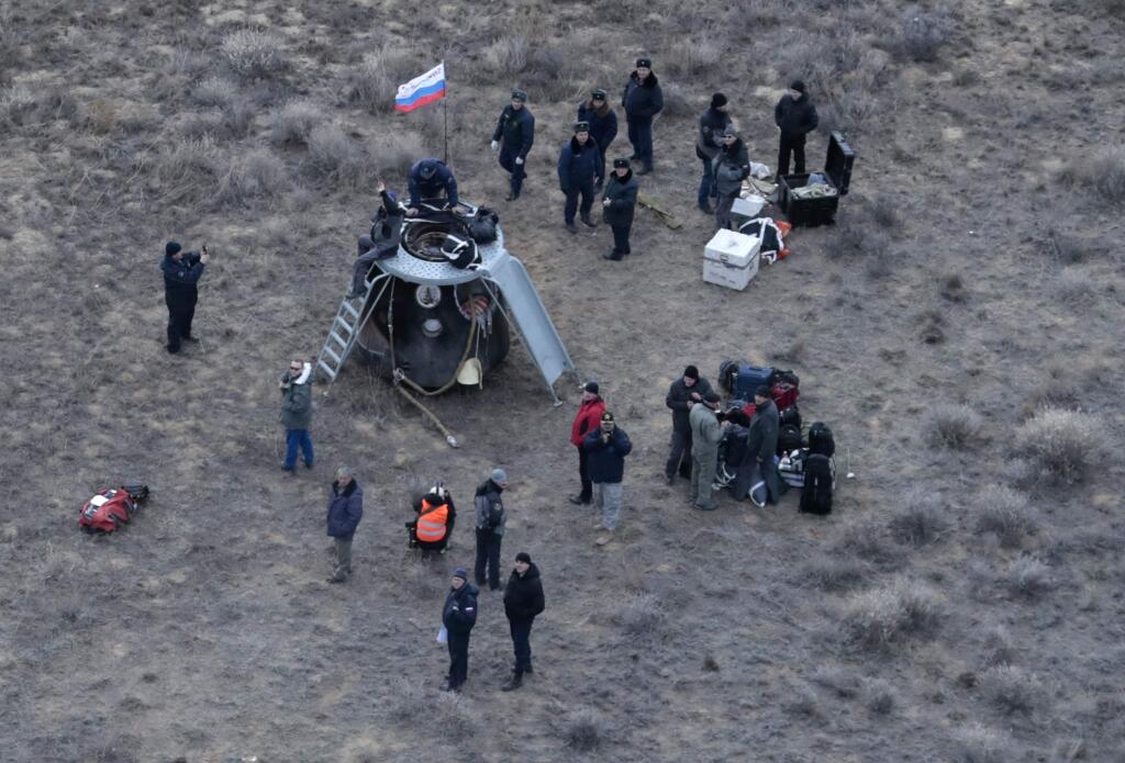 Specialists stand around the Russian Soyuz MS space capsule after its landing about 150 km (90 miles) southeast of the town of Dzhezkazgan, Kazakhstan, Sunday, Oct. 30, 2016. A Soyuz space capsule with U.S. astronaut Kate Rubins, Russian cosmonaut Anatoly Ivanishin, and Japanese astronaut Takuya Onishi, returning from a 115-day mission aboard the International Space Station landed safely Sunday on the steppes of Kazakhstan. (AP Photo/Dmitri Lovetsky, pool)