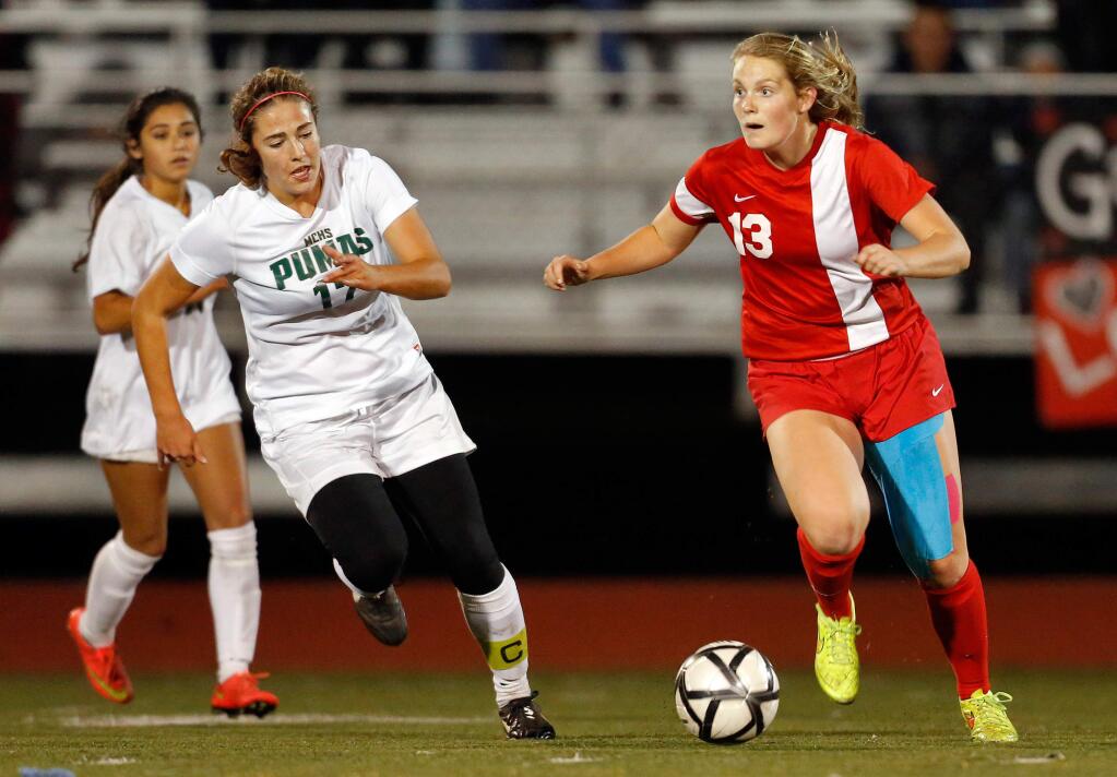 Montgomery's Taylor Ziemer (13) looks up to pass while pursued by Maria Carrillo's Sydney Rickert (17) during the first half of the NCS Division 1 championship girls soccer match in Santa Rosa on Saturday, Nov. 14, 2015. (Alvin Jornada / The Press Democrat)