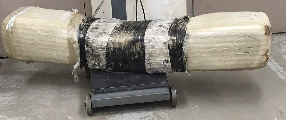 This undated photo provided by Customs and Border Protection shows a 100-pound bundle of marijuana. Border Patrol agents in southern Arizona have seized a nearly 100 pounds of marijuana after spotting it flying over the border fence. Surveillance video on Wednesday, Aug. 23, 2017, captured the large package launching through the air over the fence from Mexico to the U.S. Agents on the ground found a large, plastic-wrapped bundle worth about $48,000. (Customs and Border Protection via AP)