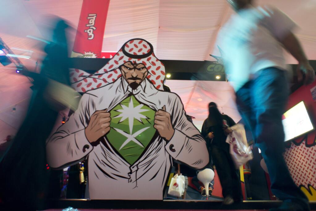 FILE - In this Friday, Feb. 17, 2017 file photo, visitors enter the Saudi Comic Con (SCC) which is the first event of its kind to be held in Jiddah, Saudi Arabia. Saudi Arabia announced on Monday Dec. 11, 2017, that movie theaters will open in the kingdom next year, for the first time in more than 35 years. (AP Photo, File)