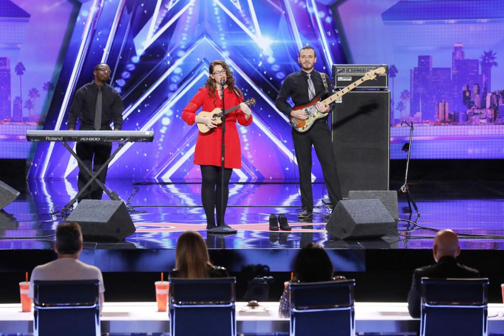 In this undated photo provided by NBC, Mandy Harvey sings during auditions for the show 'America's Got Talent' in Pasadena, Calif. Harvey, a deaf singer is moving on to the semifinals of “America's Got Talent” after delivering a performance that aired Tuesday, June 6, 2017, that judge Simon Cowell calls “one of the most amazing things” he's ever seen or heard. Mandy Harvey told the judges on the NBC reality competition that she suffers from a connective tissue disorder and she lost her hearing when she was 18. Now 29, Harvey said she taught herself to sing again using muscle memory and visual tuners. (Trae Patton/NBC via AP)