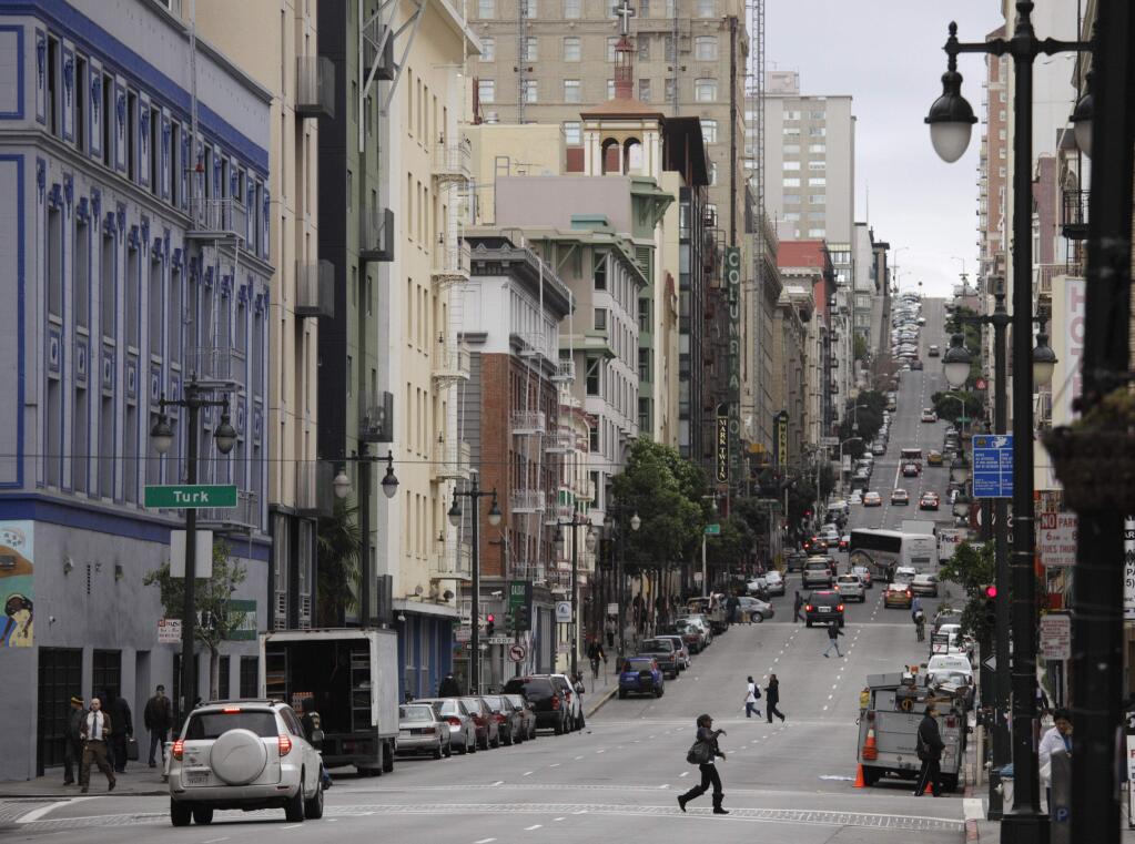 In this Feb. 15, 2011, file photo, shown is a view looking up Taylor Street of the Tenderloin neighborhood in San Francisco. Seventeen federal law enforcement agencies are teaming up for a year-long crackdown on a notorious area of San Francisco where open drug use has been tolerated for years. U.S. Attorney David Anderson said Wednesday, Aug. 7, 2019, that the federal government is targeting the city's Tenderloin neighborhood with arrests of drug traffickers as the first step in cleaning up a roughly 50-block area he says is 'smothered by lawlessness.' (AP Photo/Eric Risberg, File)