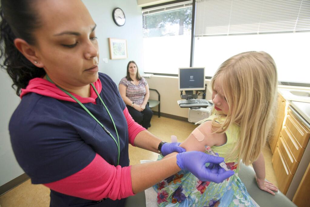 Alison Davis looks on as her daughter Hannah Hebbring, 4, of Petaluma gets her measles immunization from medical assistant Nancy Carreno at the Petaluma Health Center on Tuesday February 24, 2015. (SCOTT MANCHESTER/ARGUS-COURIER STAFF)