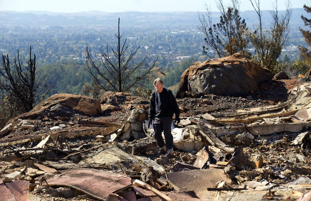 Jim Finn looks for any bits of memorabilia among the ashes of his Rocky Point Way home on the first day Fountaingrove residents were allowed to sort through the ashes of their burned out homes. (photo by John Burgess/The Press Democrat)