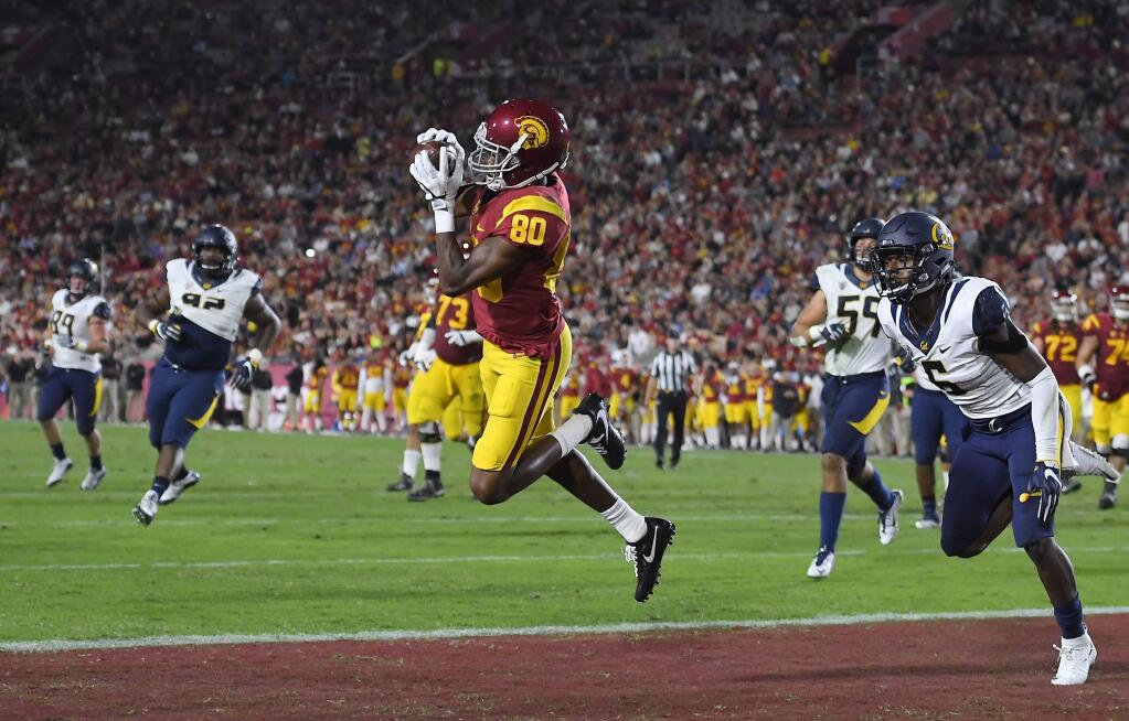 USC wide receiver Deontay Burnett, center, catches a touchdown pass as Cal safety Jaylinn Hawkins, right, defends during the first half, Thursday, Oct. 27, 2016, in Los Angeles. (AP Photo/Mark J. Terrill)