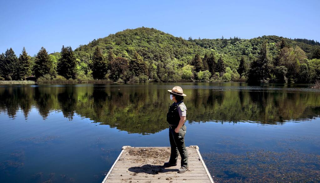 Sonoma County Regional Parks ranger Ilana Stoelting takes in the quiet space of Spring Lake, Tuesday, April 21, 2020 in Santa Rosa. Discussions are ongoing about giving residents limited time in the area parks as the shelter in place continues. (Kent Porter / The Press Democrat) 2020
