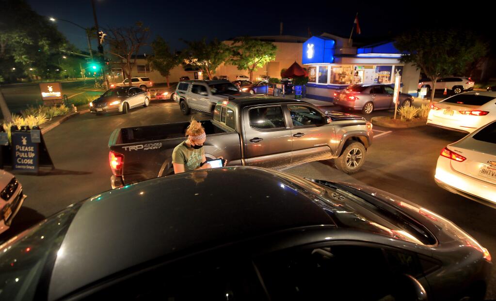 At Dutch Bros. Coffee in Santa Rosa, the line stretches around the drive thru, two lanes deep. The drive thru coffee shop is a popular go to most nights, May 6, 2020. (Kent Porter / The Press Democrat) 2020