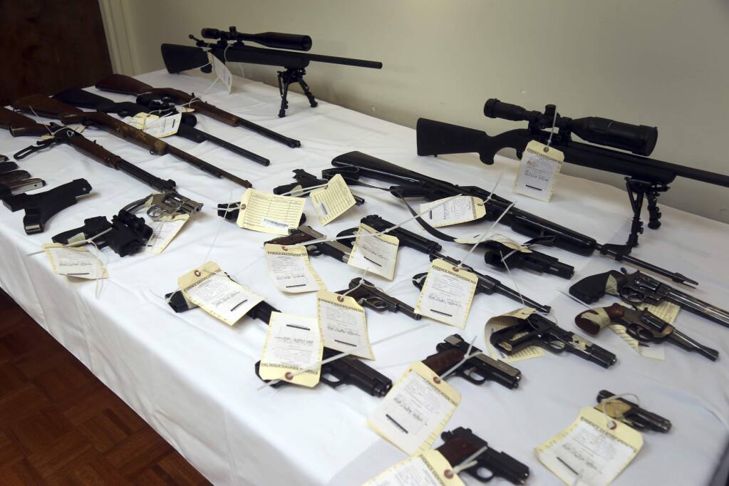 A cache of seized weapons is displayed during a press conference in Los Angeles, Calif., Tuesday, Feb. 6, 2018. Authorities have seized more than two dozen guns and thousands of rounds of ammunition from a California man, nearly five months after a judge signed an order prohibiting him from possessing firearms. (AP Photo/Mike Balsamo)