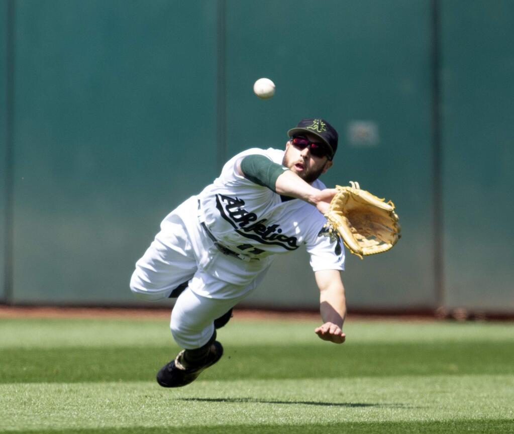 Oakland Athletics center fielder Dustin Fowler makes a diving catch on a sinking line drive by the Arizona Diamondbacks' Nick Ahmed during the eighth inning, Saturday, May 26, 2018, in Oakland. (AP Photo/D. Ross Cameron)