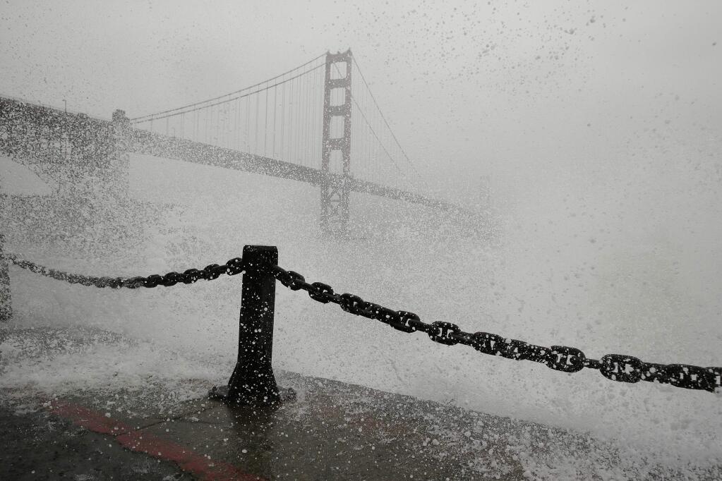 Waves crash at Fort Point with the Golden Gate Bridge in the background Thursday, Dec. 15, 2016, in San Francisco. (AP Photo/Eric Risberg)