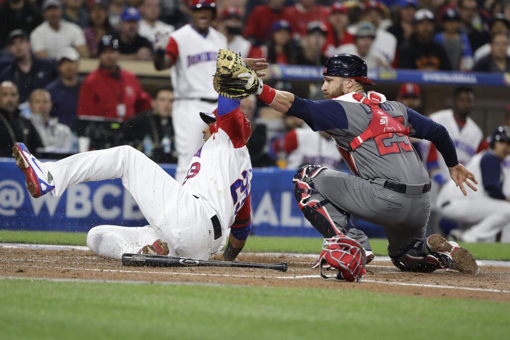 Dominican Republic's Nelson Cruz, left, is tagged out by U.S. catcher Jonathan Lucroy during the first inning of a second-round World Baseball Classic baseball game Saturday, March 18, 2017, in San Diego. (AP Photo/Gregory Bull)