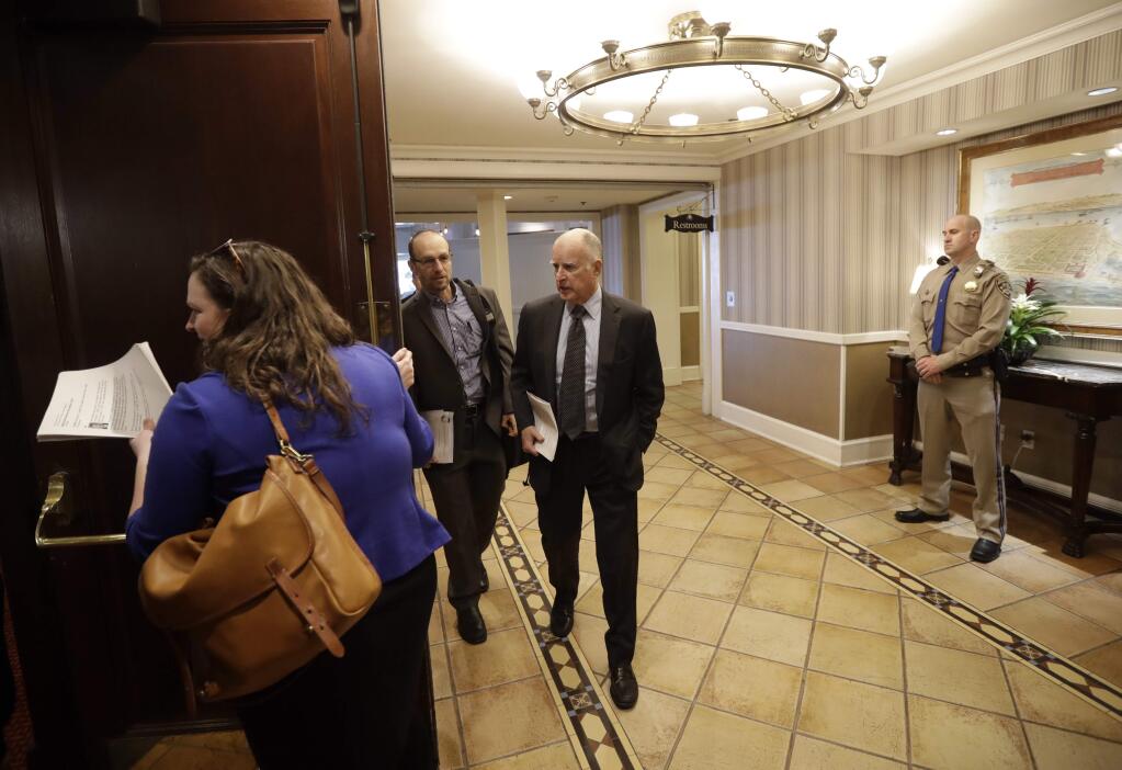California Gov. Jerry Brown, center, arrives for a news conference to launch a new organization aimed at protecting the oceans, called the International Alliance to Combat Ocean Acidification, at the Hotel del Coronado Tuesday, Dec. 13, 2016, in Coronado, Calif. Brown announced Tuesday a proposal to permanently ban new offshore oil and gas drilling in the state. (AP Photo/Gregory Bull)
