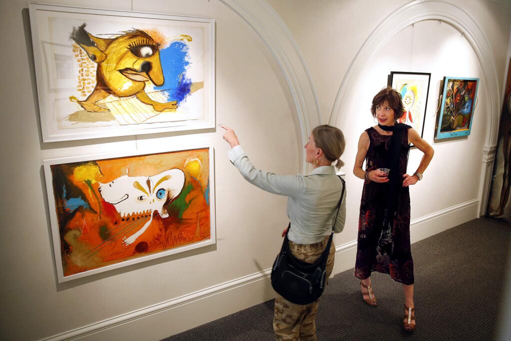 Christie Marks, right, hosts a show for artist Alejandro Salazar at the Christie Marks Gallery in Healdsburg on Saturday, June 28, 2014. (Conner Jay/The Press Democrat)