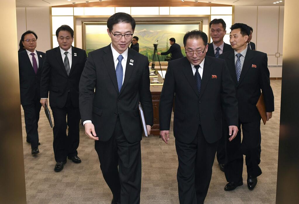 In this photo provided by South Korea Unification Ministry, South Korean Vice Unification Minister Chun Hae-sung, center left, and the head of North Korean delegation Jon Jong Su leave after a meeting at Panmunjom in the Demilitarized Zone in Paju, South Korea, Wednesday, Jan. 17, 2018. The rival Koreas agreed Wednesday to form their first unified Olympic team and have their athletes parade together during the opening ceremony of next month's Winter Olympics in the South, Seoul officials said. (South Korea Unification Ministry via AP)