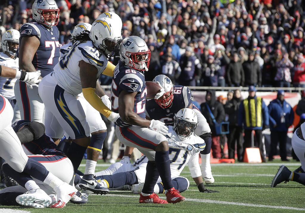 New England Patriots running back Sony Michel (26) scores a touchdown in front of Los Angeles Chargers defensive tackle Darius Philon (93) during the first half of an NFL divisional playoff football game, Sunday, Jan. 13, 2019, in Foxborough, Mass. (AP Photo/Steven Senne)