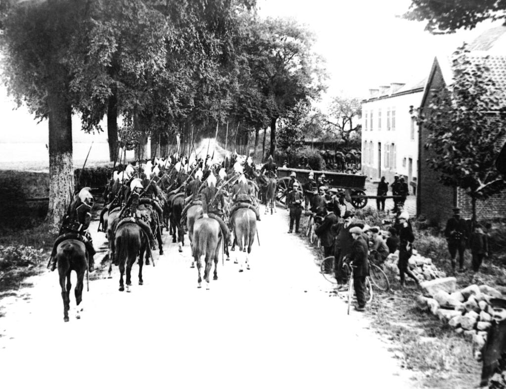 FILE - Lancers on horseback enter a Belgium village in the first days of the war on the Western Front in a 1914 photo. They were messengers, spies, sentinels and the heavy haulers of World War I, carrying supplies, munitions and food and leading cavalry charges. The horses, mules, dogs and pigeons were a vital part of the Allied war machine, saving countless lives _ and dying by the millions. (AP Photo, File)