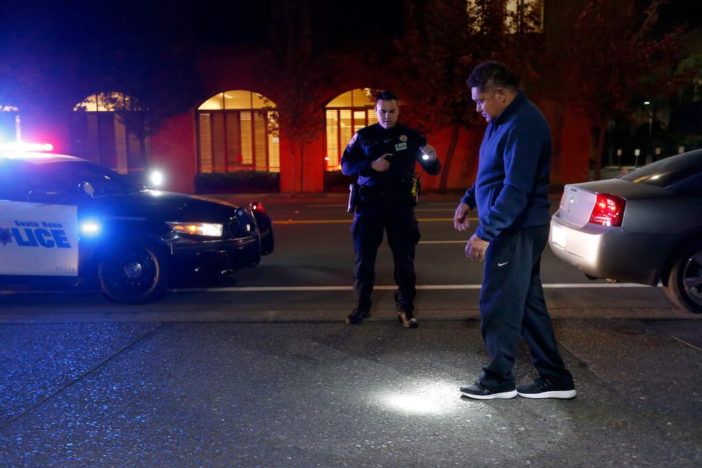 Santa Rosa police officer Ken Ferrigno issues a field sobriety test to Alberto Bojorquez-Quintero, who was pulled over because he was unable to maintain his lane, during a DUI enforcement patrol in Santa Rosa, California, on Thursday, December 1, 2016. Bojorquez-Quintero passed the sobriety test but received a ticket for driving with a suspended license due to a previous DUI. (Alvin Jornada / The Press Democrat)