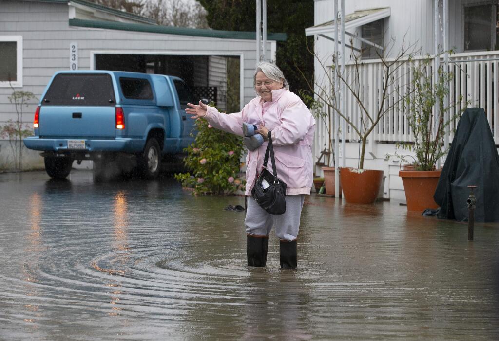 Christine Brown wades through water to reach her son's truck outside her mobile home in the Colonial Park Mobile Home Estates in Santa Rosa on Tuesday, Feb. 26, 2019. (JOHN BURGESS/ PD)
