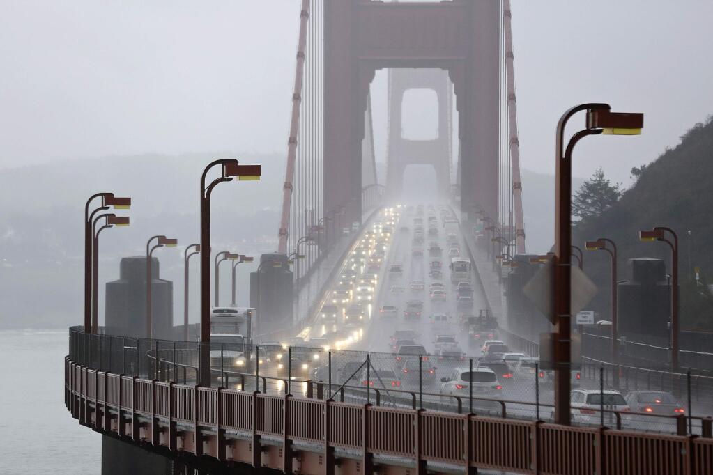 FILE - In this Jan. 5, 2016, file photo, traffic crosses the Golden Gate Bridge in the rain in this view from Sausalito, Calif. The Trump administration has ended its antitrust probe into a deal between California and four big automakers, after failing to find that the companies' conduct violated the law. (AP Photo/Eric Risberg, File)