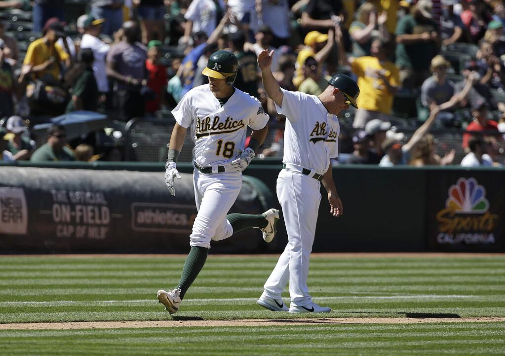 The Oakland Athletics' Chad Pinder is congratulated by third base coach Chip Hale after hitting a two-run home run against the Boston Red Sox during the fifth inning Saturday, May 20, 2017. (AP Photo/Jeff Chiu)