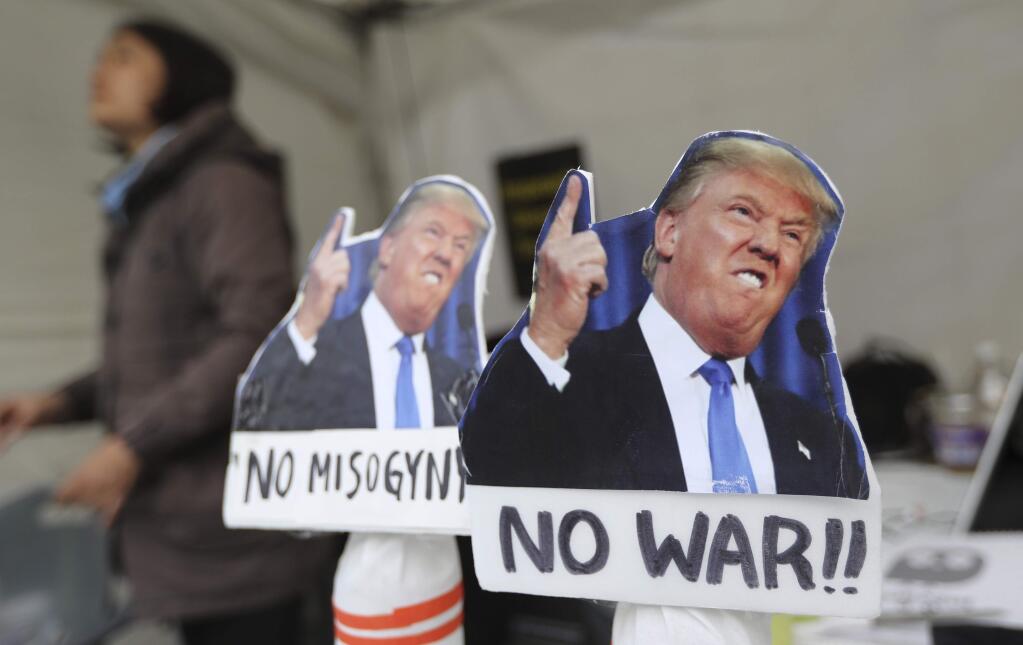 Pictures of U.S. President Donald Trump are displayed near the venue for anti-war rally in Seoul, South Korea, Tuesday, Nov. 7, 2017. South Korean police were on high alert in Seoul on Tuesday to monitor protests by both critics and supporters of President Donald Trump as the U.S. leader arrived in the country amid concerns over North Korea's nuclear threats. (AP Photo/Lee Jin-man)
