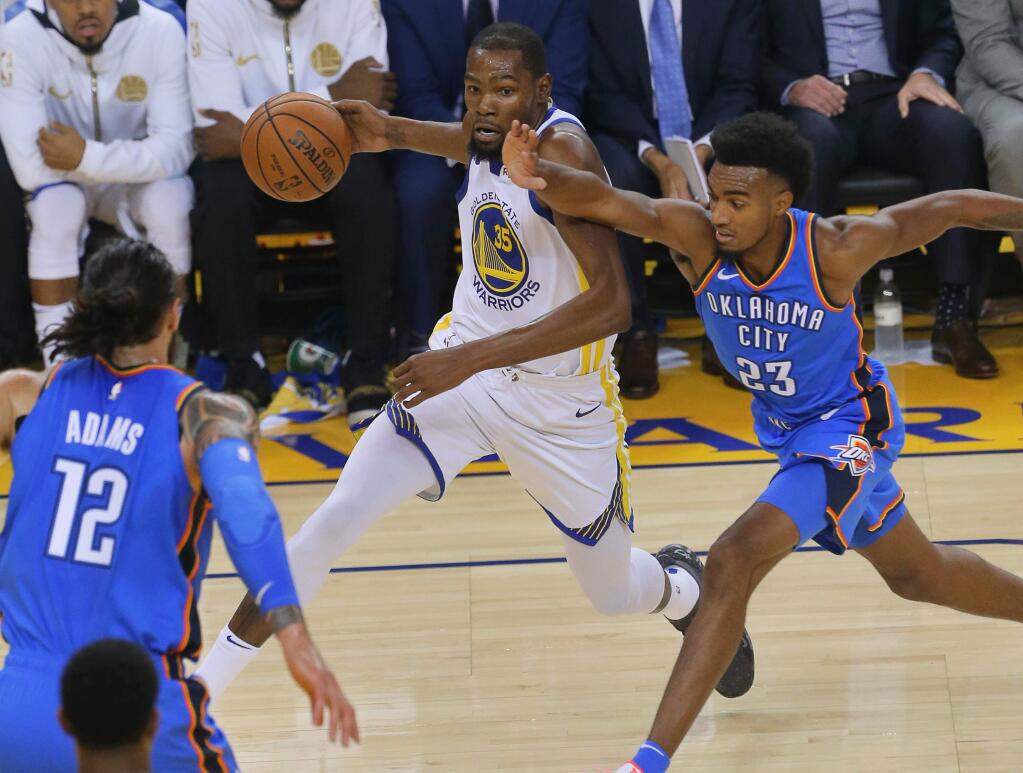 Golden State Warriors forward Kevin Durant drives past Oklahoma City Thunder guard Terrance Ferguson, in Oakland on Tuesday, October 16, 2018. (Christopher Chung/ The Press Democrat)