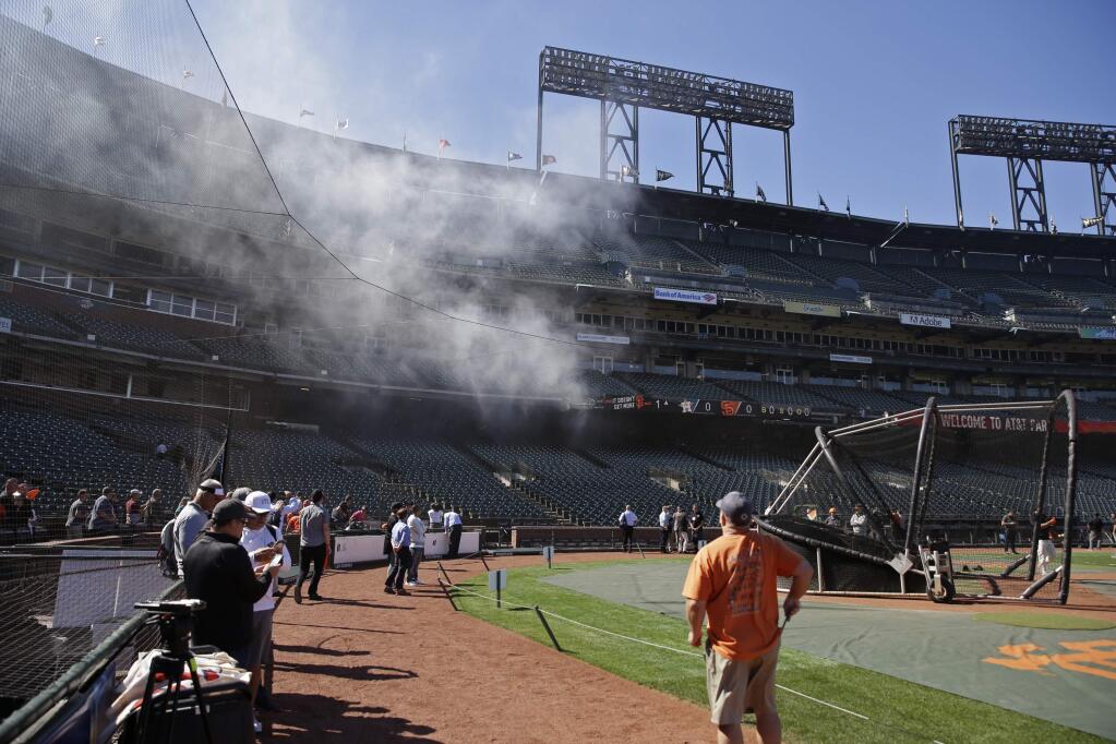 Smoke from a concession stand fire filters out to the seats at AT&T Park before a baseball game between the Houston Astros and the San Francisco Giants, Monday, Aug. 6, 2018, in San Francisco. The fire was put out by the time firemen arrived and there was no expected delay of the game. (AP Photo/Eric Risberg)