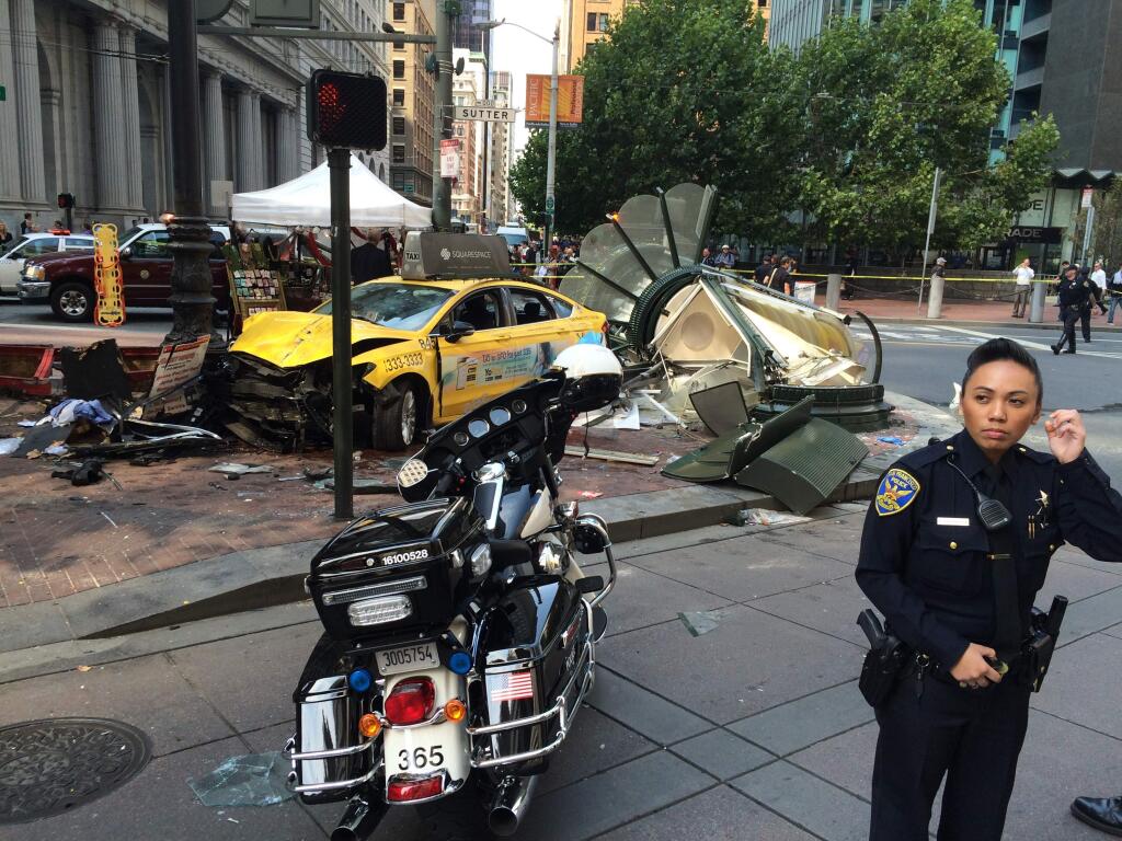 San Francisco Police Officer Grace Gatpandan, right, stands by the scene of a taxi crash in downtown San Francisco Tuesday, Aug. 23, 2016. (AP Photo/Paul J. Elias)
