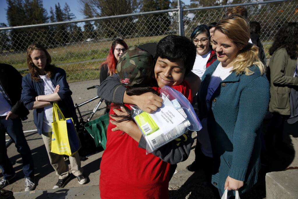 Matthew Quezada, 16, a member of Elsie Allen High School's Interact Club, hugs Ella Want, a resident of the Roseland homeless encampment after listening to her talk about what its like to be homeless in Santa Rosa, on Sunday, March 4, 2018. (BETH SCHLANKER/ The Press Democrat)