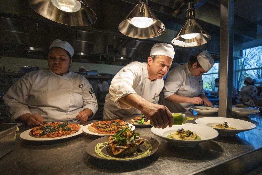 From left, Gabby Are, Rick Baum and Kody-Michele Hamlow put the finishing touches on plates before sending them out to table at the Santa Rosa Junior College Culinary Cafe opening day on Wednesday. (photo by John Burgess/The Press Democrat)