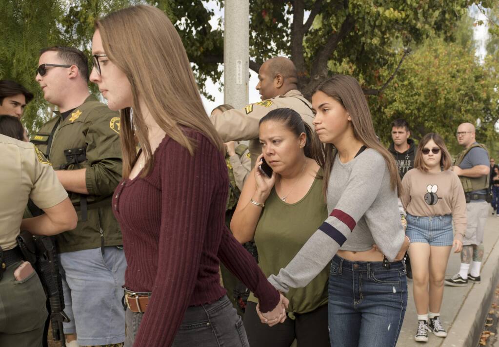 Students evacuate their campus after reports of a shooting at Saugus High School on Thursday, Nov. 14, 2019 in Santa Clarita, Calif. The shooting occurred around 7:30 a.m. at the high school, about 30 miles (48 kilometers) northwest of downtown Los Angeles. (AP Photo by Christian Monterrosa)