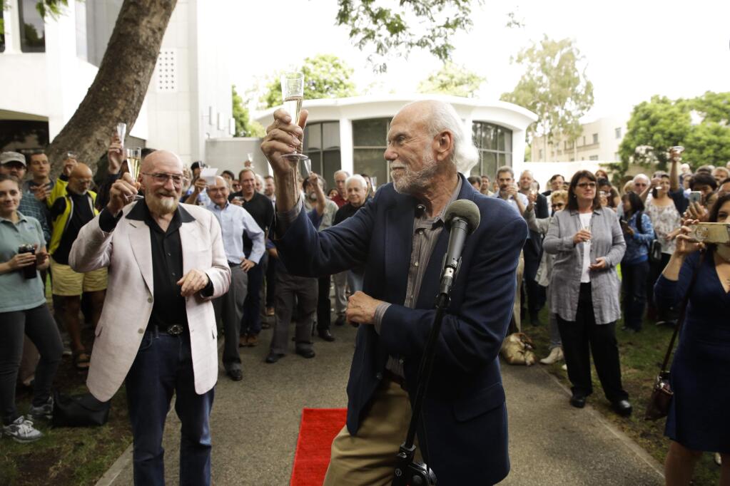 Scientists Barry Barish, center, and Kip Thorne, both of the California Institute of Technology, share a toast to celebrate winning the Nobel Prize in Physics Tuesday, Oct. 3, 2017, in Pasadena, Calif. Barish and Thorne won the Nobel Physics Prize on Tuesday for detecting faint ripples flying through the universe, the gravitational waves predicted a century ago by Albert Einstein that provide a new understanding of the universe. (AP Photo/Jae C. Hong)