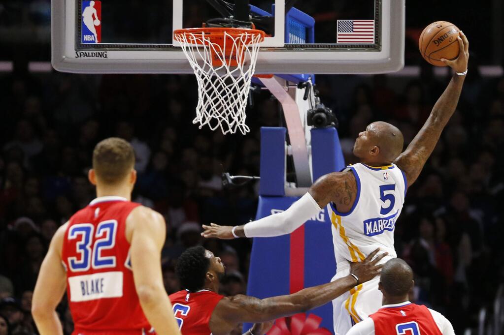 Golden State Warriors' Marreese Speights, top right, goes up to dunk over Los Angeles Clippers', from left to right, Blake Griffin, DeAndre Jordan and Chris Paul during the first half of an NBA basketball game Thursday, Dec. 25, 2014, in Los Angeles. (AP Photo/Danny Moloshok)