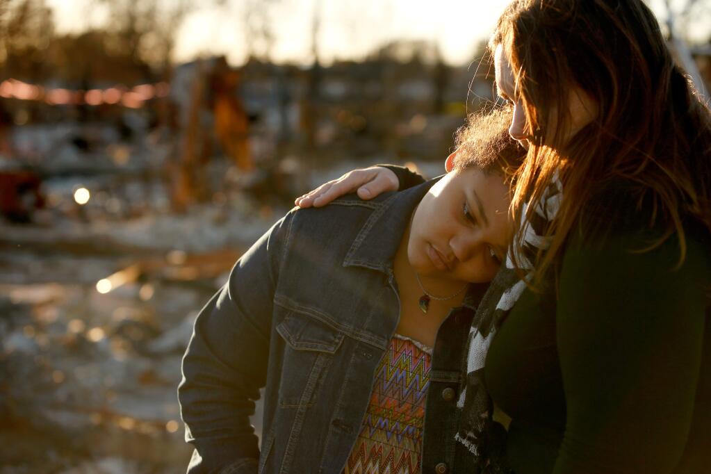 Amy Marlar embraces her daughter Logyn, 11, as they stand on what used to be the front porch of their Santiago Drive home that was destroyed by the Tubbs Fire, in the Coffey Park neighborhood of Santa Rosa, California on Wednesday, December 20, 2017. (Alvin Jornada / The Press Democrat)