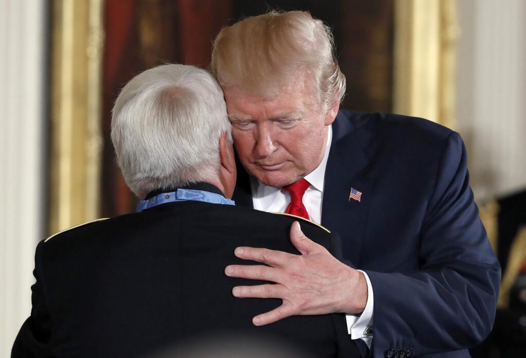 President Donald Trump listens as retired Army medic James McCloughan speaks to him, after bestowing the nation's highest military honor, the Medal of Honor, to McCloughan, during a ceremony in the East Room of the White House, Monday, July 31, 2017, at Washington. McCloughan is credited with saving the lives of members of his platoon nearly 50 years ago in the Battle of Nui Yon Hill in Vietnam. (AP Photo/Alex Brandon)