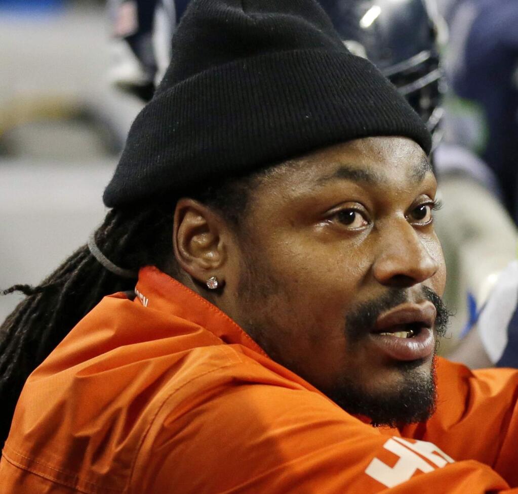 FILE - In this Dec. 4, 2016, file photo, retired Seattle Seahawks running back Marshawn Lynch, left, chats on the sidelines players on the bench in the second half of an NFL football game against the Carolina Panthers in Seattle. A person familiar with the deal tells The Associated Press that the Oakland Raiders have agreed to a two-year contract to bring running back Marshawn Lynch out of retirement. The person says the sides have agreed on the terms pending a physical for Lynch on Wednesday, April 26, 2017. The person spoke to the AP on condition of anonymity because the contract has not been finalized. (AP Photo/Ted S. Warren, File)
