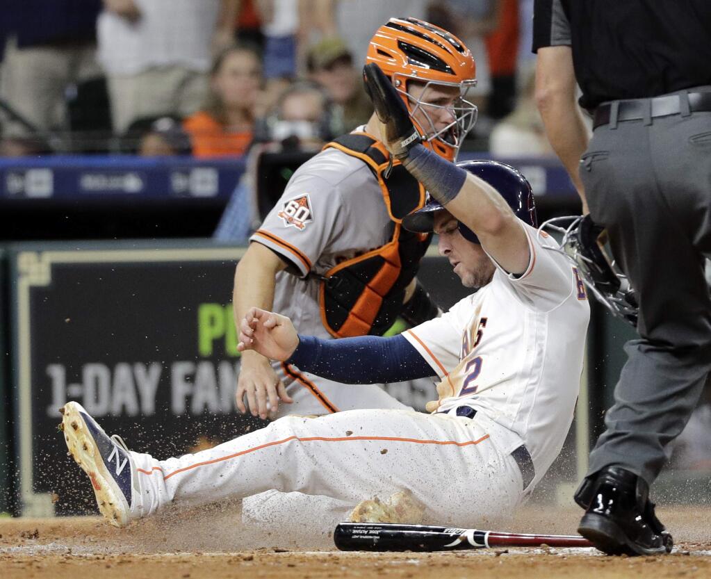 The Houston Astros' Alex Bregman slides safely across home plate as San Francisco Giants catcher Buster Posey handles the throw during the sixth inning Tuesday, May 22, 2018, in Houston. (AP Photo/David J. Phillip)