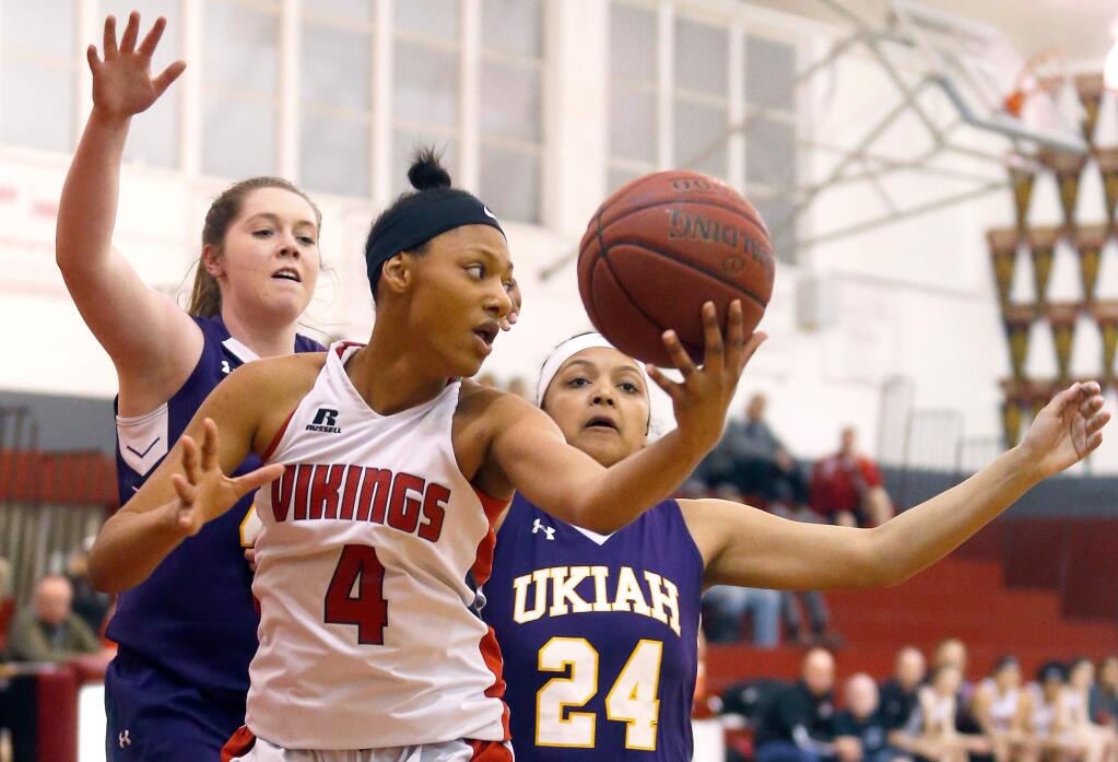 Montgomery's Trinity Hawkins (4), center, grabs an offensive rebound in front of Ukiah's Kirsten Johnson (44), left, and Natae Henson (24) during the first half of the NBL semifinal girls varsity basketball game between Ukiah and Montgomery high schools in Santa Rosa, California, on Tuesday, February 13, 2018. (Alvin Jornada / The Press Democrat)