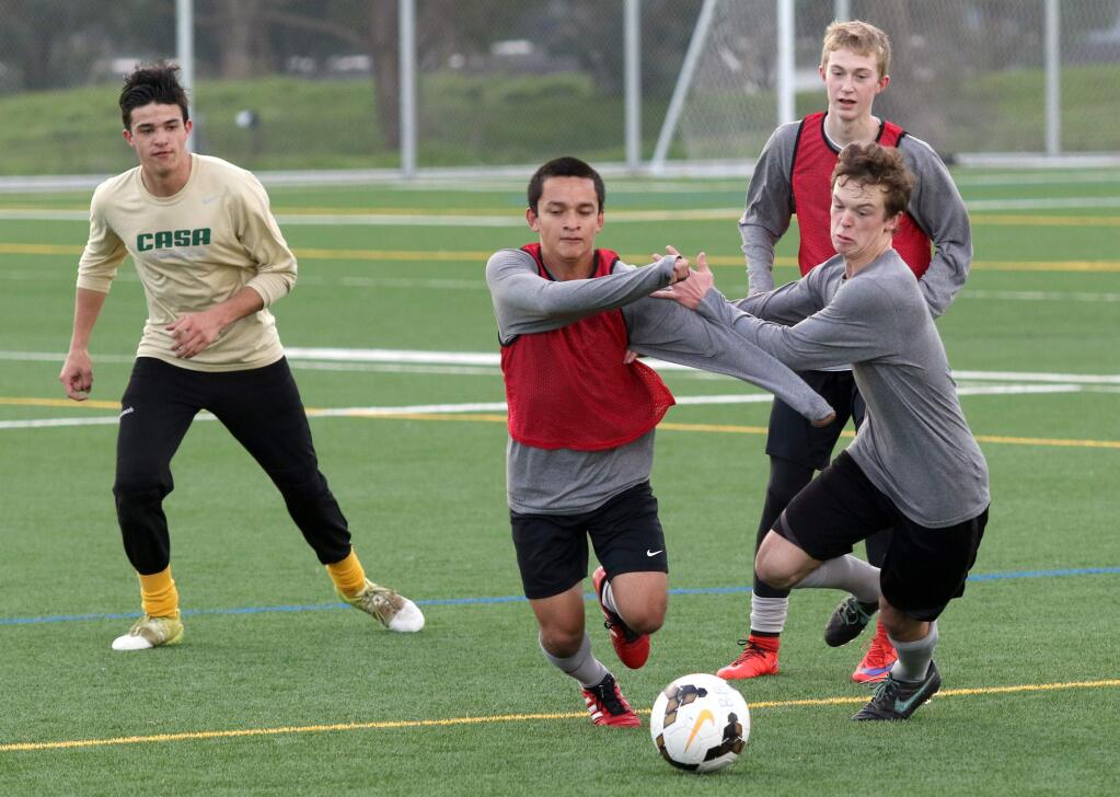 Danny Ajquiy, left, and Will Lewczyk fight for control of the ball as Kyle Harmina, left, and Jack Guns keep their eyes on the action during practice of the Casa Grande High School boys soccer team at East Washington Street Park Fields in Petaluma on Monday, February 1, 2016. (SCOTT MANCHESTER/ARGUS-COURIER STAFF)