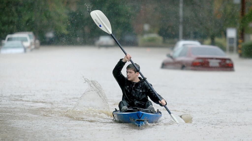KENT PORTER / The Press DemocratKinsnan VanGerpen kayaks through floodwaters in Healdsburg on Thursday.