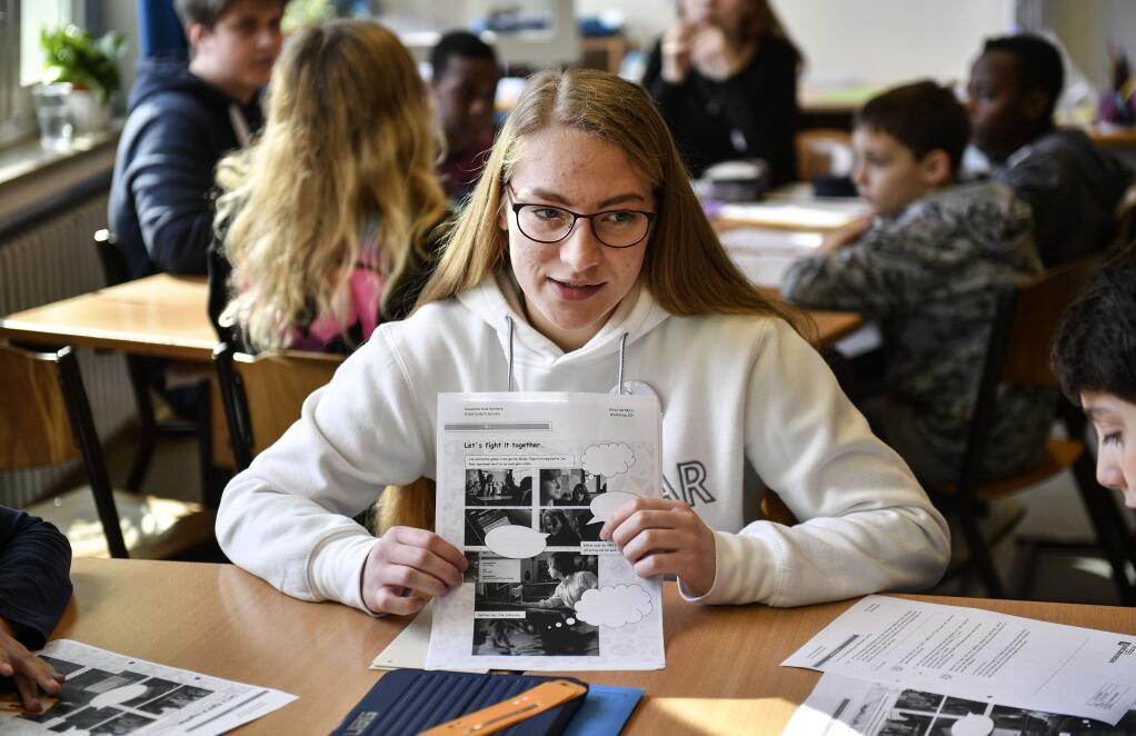 Senior student and media scout Joeline Klaar teaches young pupils during a lesson in social media and internet at a comprehensive school in Essen, Germany, Monday, March 18, 2019. According to experts and teachers the peer projects in which teenagers teach their younger schoolmates how to stay safe and sane online have proven to be especially successful. (AP Photo/Martin Meissner)