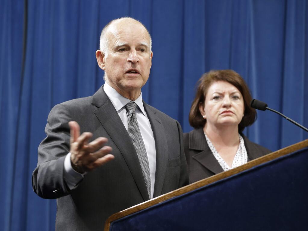 Calif., Gov. Jerry Brown answers a question concerning the budget agreement reached with legislative leaders at a Capitol news conference in Sacramento, Calif., Tuesday, June 16, 2015. Accompanied by Assembly Speaker Toni Atkins, D-San Diego, right, and Senate President Pro Tem Kevin de Leon, D-Los Angeles, unseen, Brown outlined the budget plan that send billions more to public schools and universities in the fiscal year that begins July 1. (AP Photo/Rich Pedroncelli)