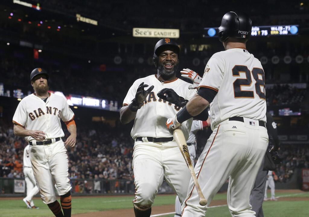 The San Francisco Giants' Buster Posey, right, waits to congratulate Denard Span, center, and Hunter Pence, left, after both scored during the fifth inning against the Philadelphia Phillies in San Francisco, Thursday, Aug. 17, 2017. (AP Photo/Jeff Chiu)