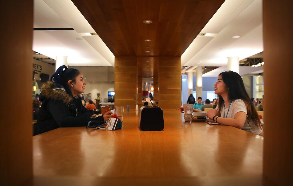 Sonoma State University freshmen Roxette Isidro, right, and Janelis Munguia talk over lunch at the Kitchens, in SSU's Student Center, in Rohnert Park on Wednesday, February 8, 2017. (Christopher Chung/ The Press Democrat)